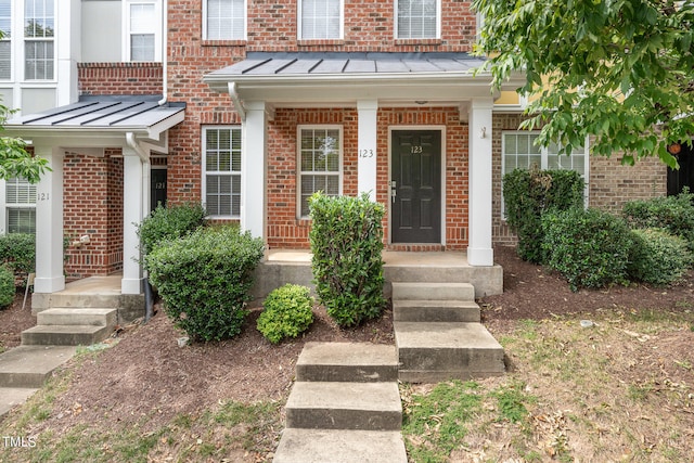 view of exterior entry featuring covered porch