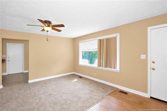 carpeted empty room featuring a textured ceiling and ceiling fan