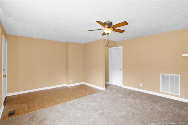 carpeted spare room with a textured ceiling and ceiling fan