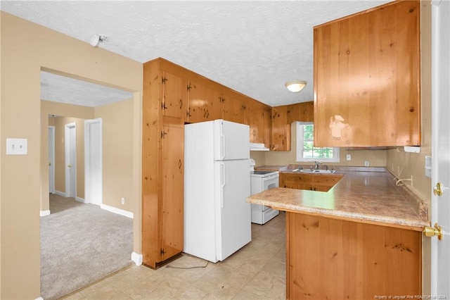 kitchen featuring a textured ceiling, white appliances, light carpet, kitchen peninsula, and sink