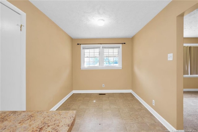 spare room with a textured ceiling