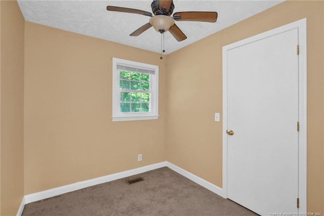 empty room with a textured ceiling, carpet, and ceiling fan