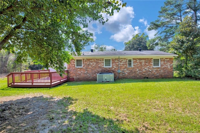 rear view of house featuring central air condition unit, a yard, and a deck