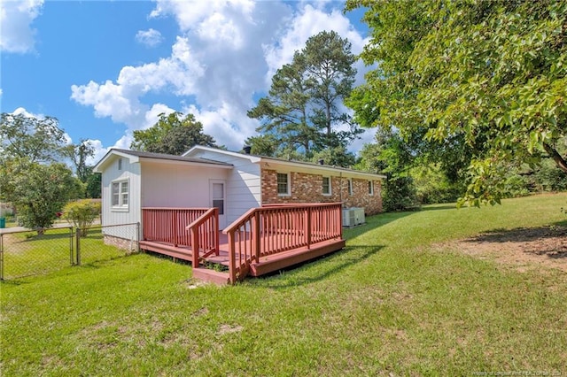 back of property with a yard and a wooden deck