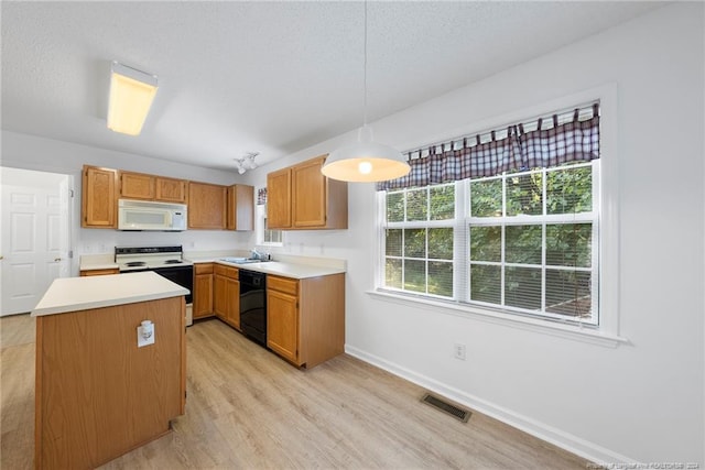 kitchen featuring decorative light fixtures, white appliances, light hardwood / wood-style floors, sink, and a textured ceiling