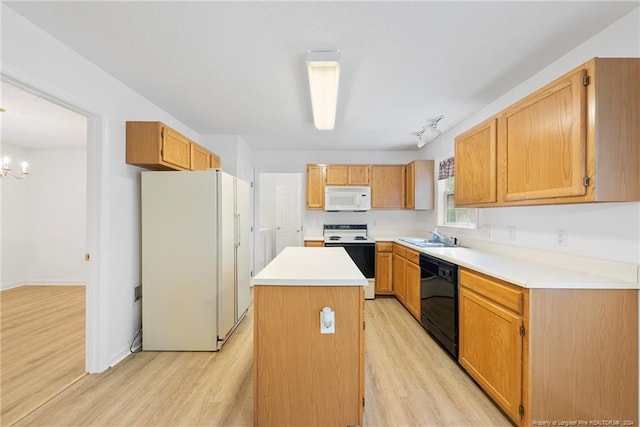 kitchen featuring a kitchen island, a notable chandelier, light hardwood / wood-style flooring, and white appliances