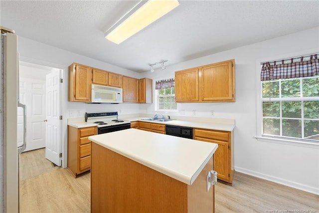 kitchen featuring light wood-type flooring, white appliances, a center island, and sink