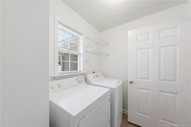 washroom with independent washer and dryer and a textured ceiling