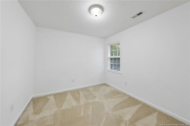 carpeted spare room featuring a textured ceiling