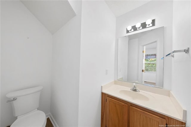 bathroom with vanity, toilet, and vaulted ceiling