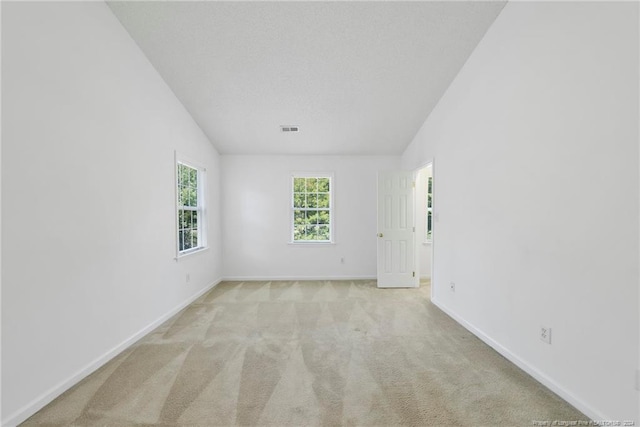 carpeted spare room with vaulted ceiling