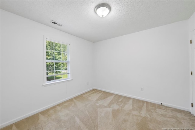 carpeted empty room with a textured ceiling