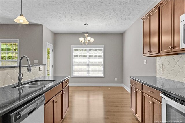 kitchen featuring dishwasher, a healthy amount of sunlight, backsplash, and sink