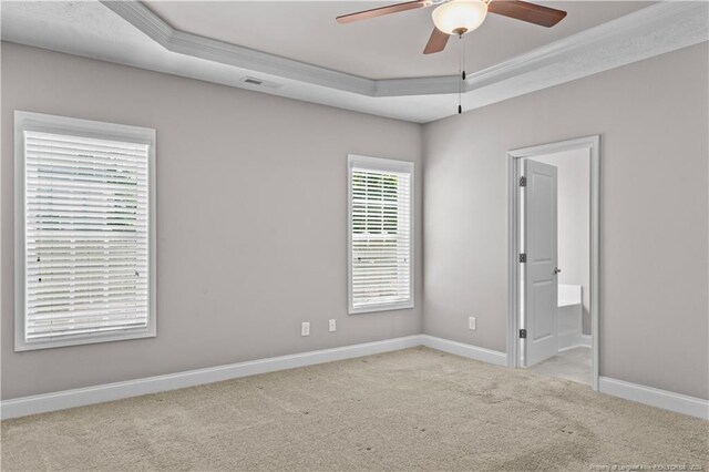 carpeted empty room featuring a tray ceiling, ceiling fan, and ornamental molding