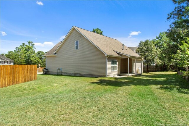 rear view of house featuring a yard and a patio