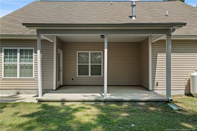 doorway to property featuring a yard and a porch