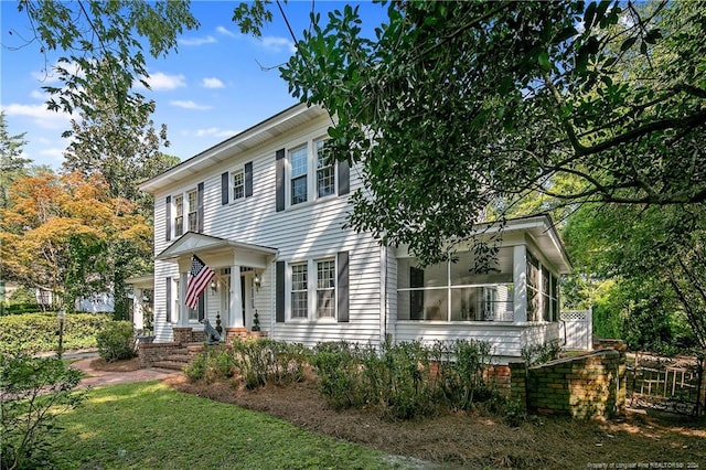 colonial house featuring a front lawn