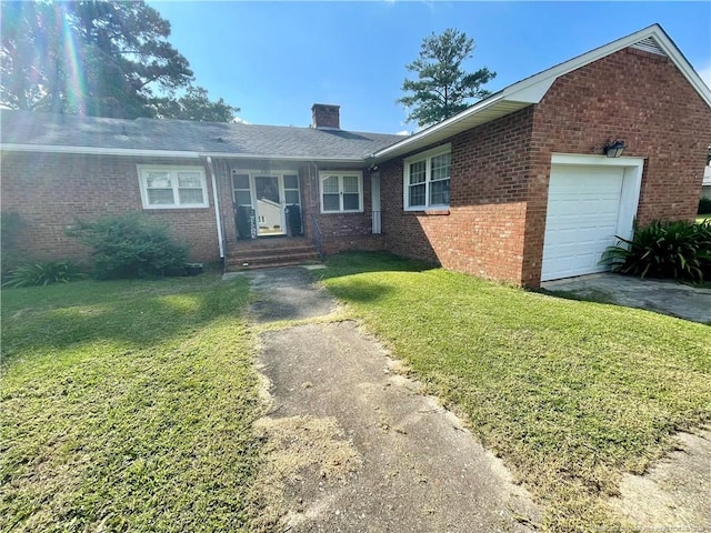 ranch-style home with a garage and a front lawn