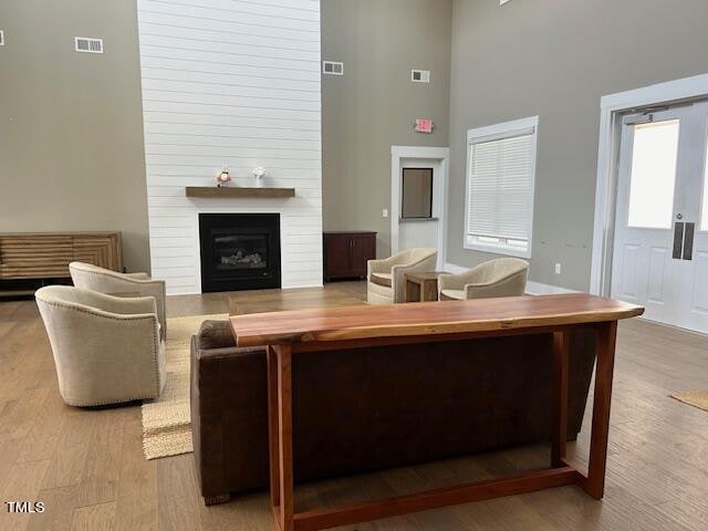 living room featuring a towering ceiling and light hardwood / wood-style flooring