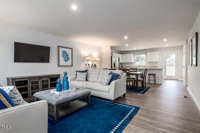 living room with wood-type flooring and a textured ceiling