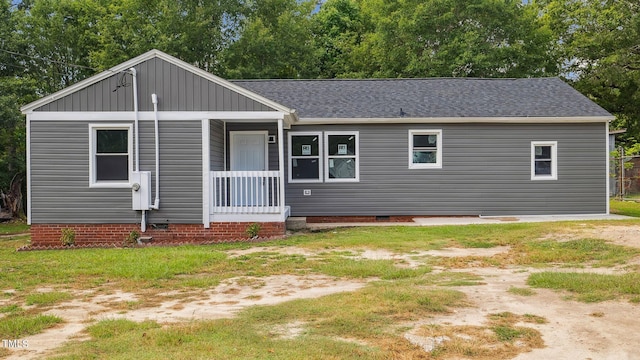 view of front facade with crawl space, a front yard, and roof with shingles