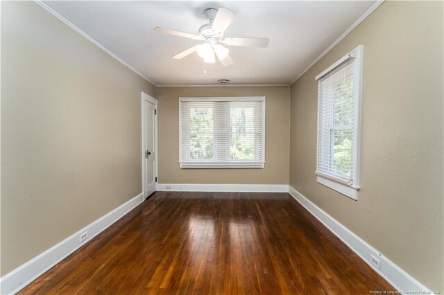 empty room with ceiling fan, dark hardwood / wood-style floors, crown molding, and a healthy amount of sunlight