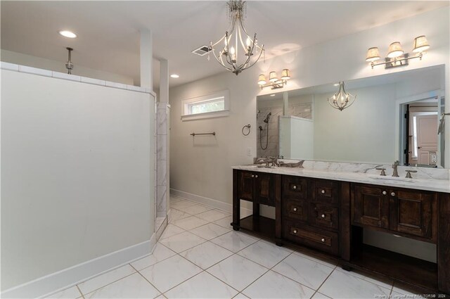 bathroom featuring tile patterned flooring, vanity, a notable chandelier, and a tile shower