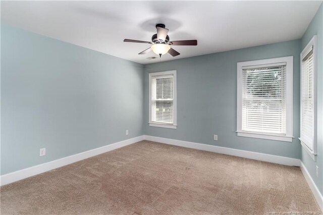 spare room featuring ceiling fan and carpet