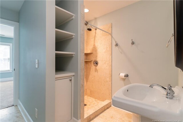 bathroom featuring a shower, tile patterned flooring, and sink