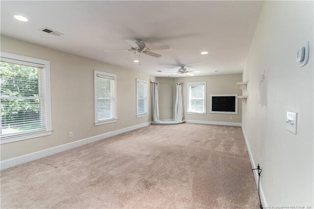 empty room featuring ceiling fan and light carpet