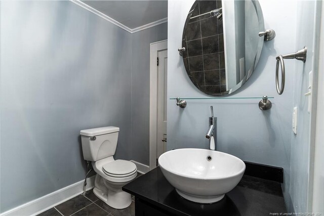 bathroom with tile patterned floors, toilet, crown molding, and vanity