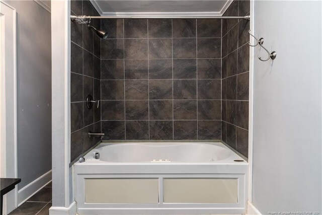 bathroom featuring tiled shower / bath combo, crown molding, and tile patterned floors