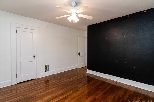 spare room featuring dark hardwood / wood-style flooring and ceiling fan