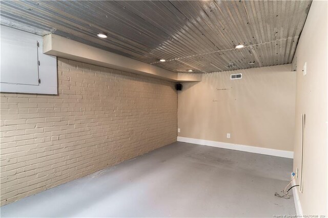 basement with wood ceiling and brick wall