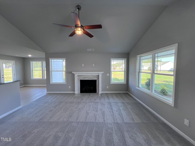 unfurnished living room featuring light colored carpet, a premium fireplace, plenty of natural light, and ceiling fan