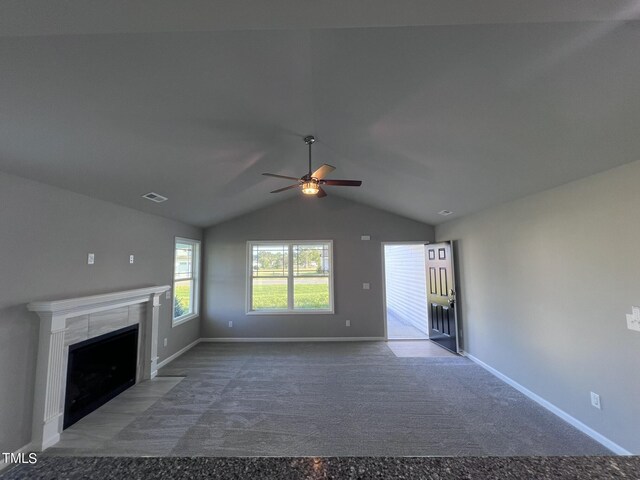 unfurnished living room with lofted ceiling, ceiling fan, a fireplace, and carpet floors