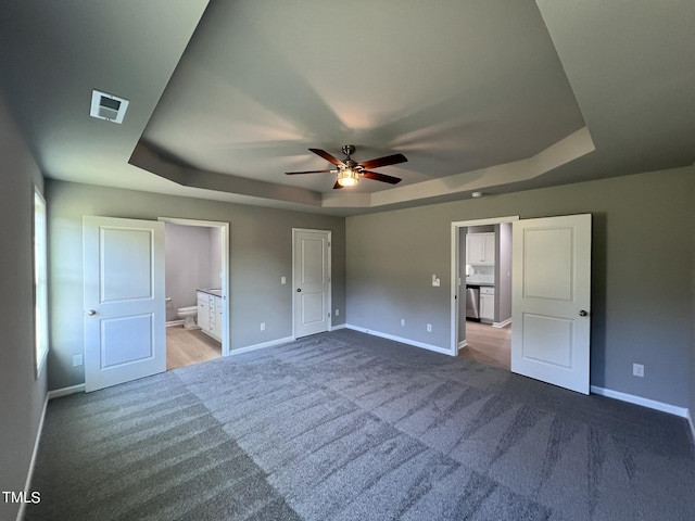 194 Lotus Ave, Smithfield, NC 27577 - unfurnished bedroom with baseboards, visible vents, ensuite bathroom, and a raised ceiling
