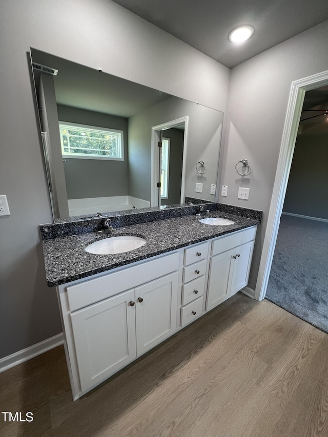 194 Lotus Ave, Smithfield, NC 27577 - full bathroom with double vanity, a sink, baseboards, and wood finished floors