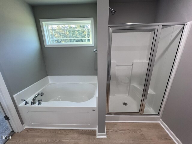 bathroom with hardwood / wood-style floors and plus walk in shower