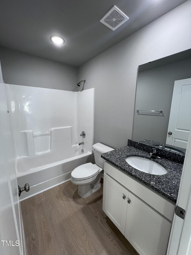 full bathroom featuring vanity, toilet, bathtub / shower combination, and hardwood / wood-style flooring