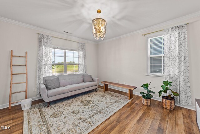 living room with wood-type flooring, crown molding, and an inviting chandelier