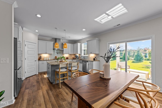 dining space with crown molding, dark hardwood / wood-style flooring, and sink