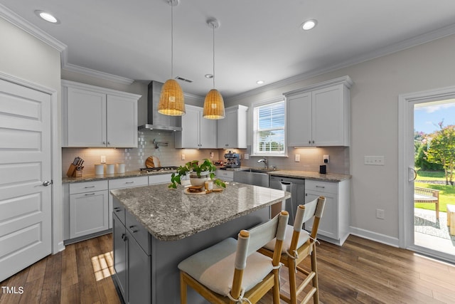 kitchen with a center island, dark hardwood / wood-style floors, white cabinets, wall chimney exhaust hood, and decorative light fixtures