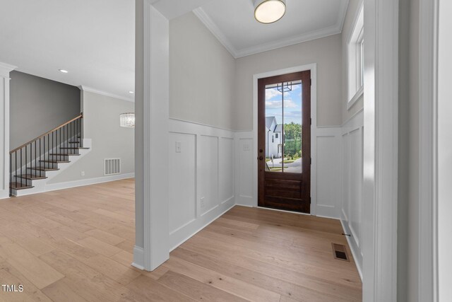 foyer entrance featuring ornamental molding and light hardwood / wood-style floors