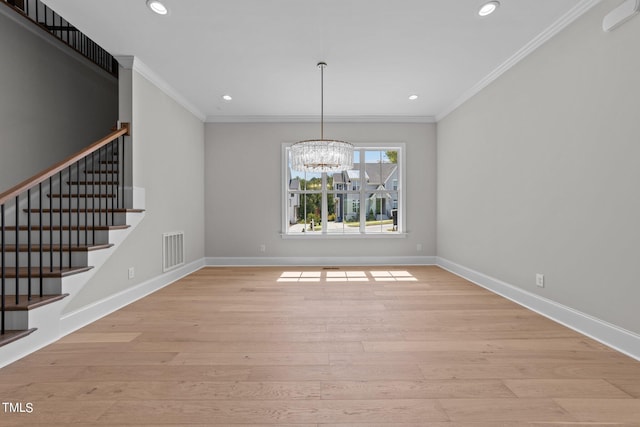 unfurnished dining area with crown molding, light hardwood / wood-style floors, and a chandelier