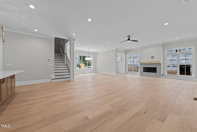 unfurnished living room featuring light hardwood / wood-style flooring, ceiling fan, and crown molding