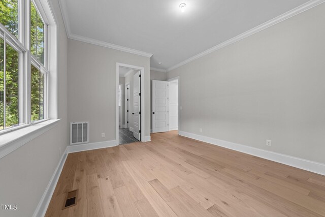 unfurnished bedroom featuring light hardwood / wood-style flooring, crown molding, and multiple windows