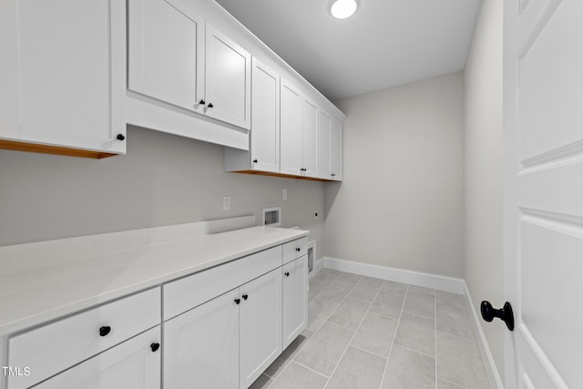 laundry room with cabinets, electric dryer hookup, washer hookup, and light tile patterned floors