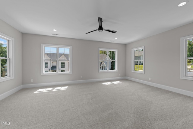 spare room featuring a healthy amount of sunlight, light carpet, and ceiling fan