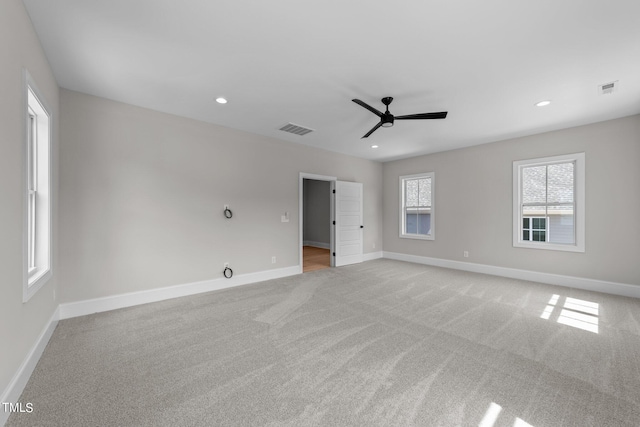 spare room with ceiling fan and light carpet